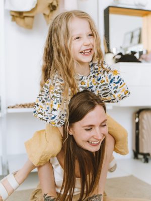 Mother carrying her daughter smiling